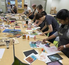 Adults during an art class making prints.