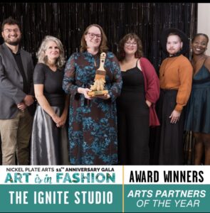 6 people holding a paintbrush trophy. Caption reads Nickelplate Arts Ignite Studio Arts Partner of the Year.