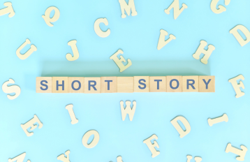 Blue background with white letters and scrabble letter squares spelling out "short story"