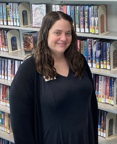 Woman standing in front of bookshelf