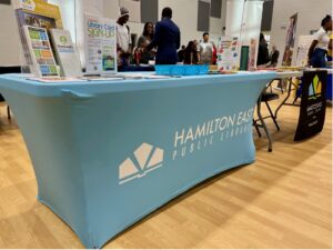 table with blue tablecloth that says Hamilton East Public Library