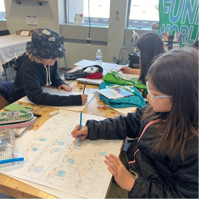 Three girls drawing comics