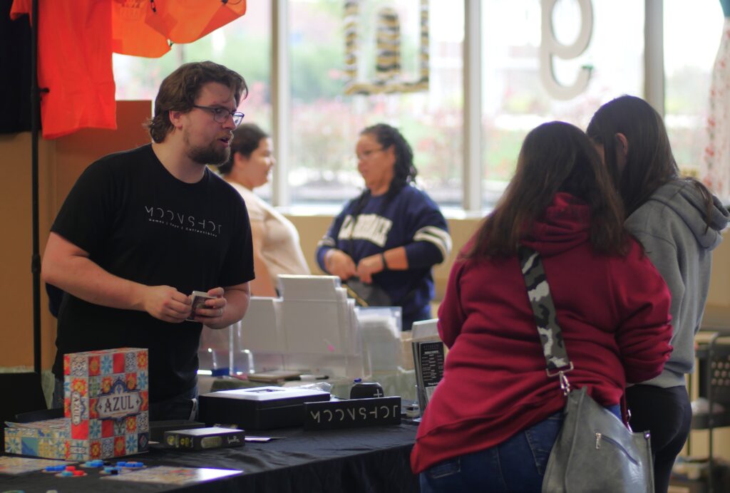 vendor at a booth talking to a visitor