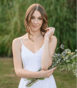 A girl in a white dress holding flowers