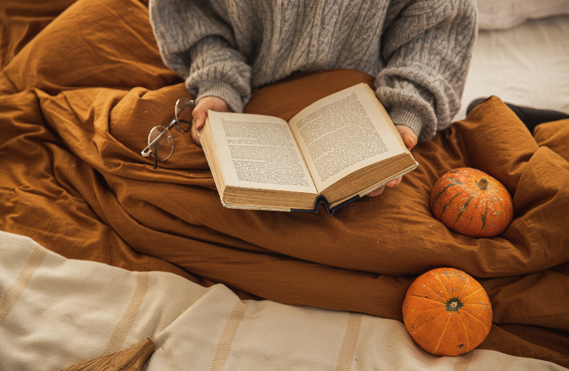 reading book with pumpkins person reading a book in bed with pumpkins