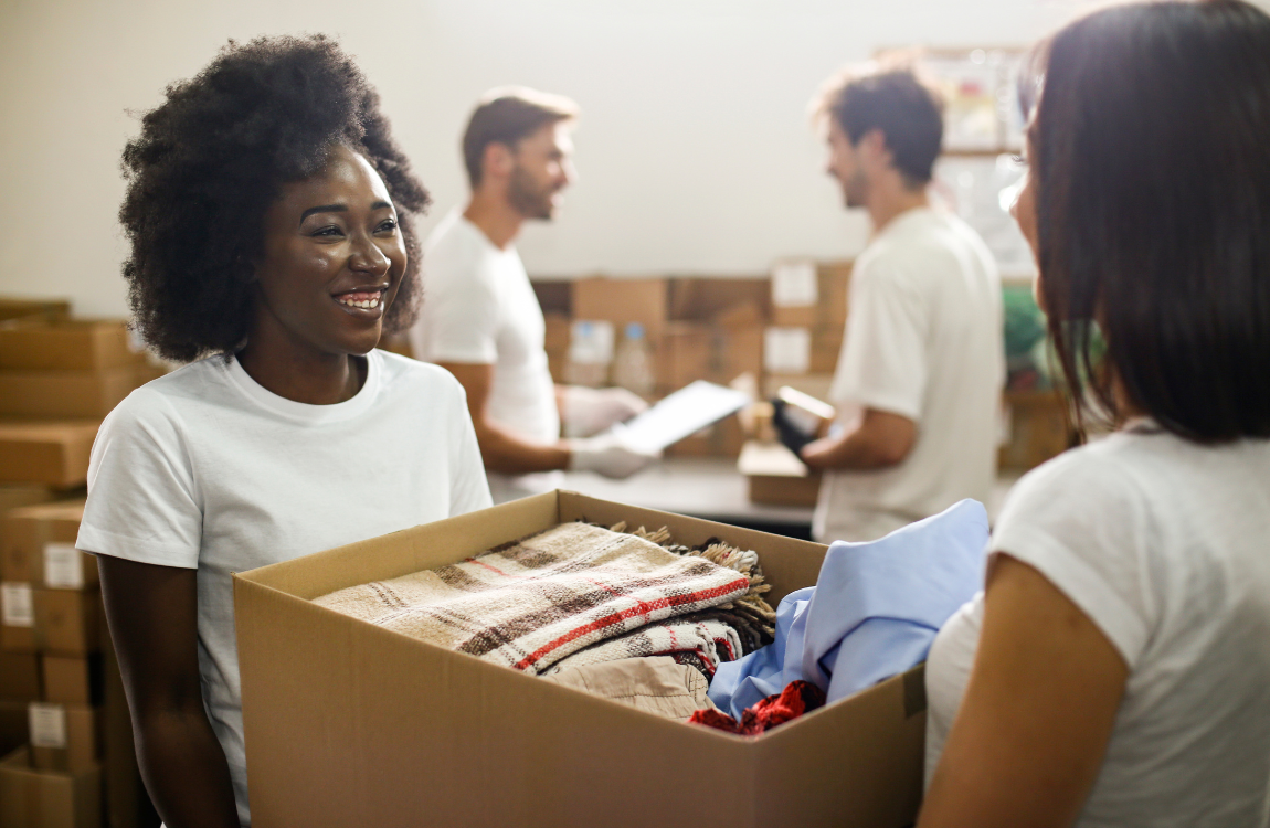 donations woman handing box of donations to staff