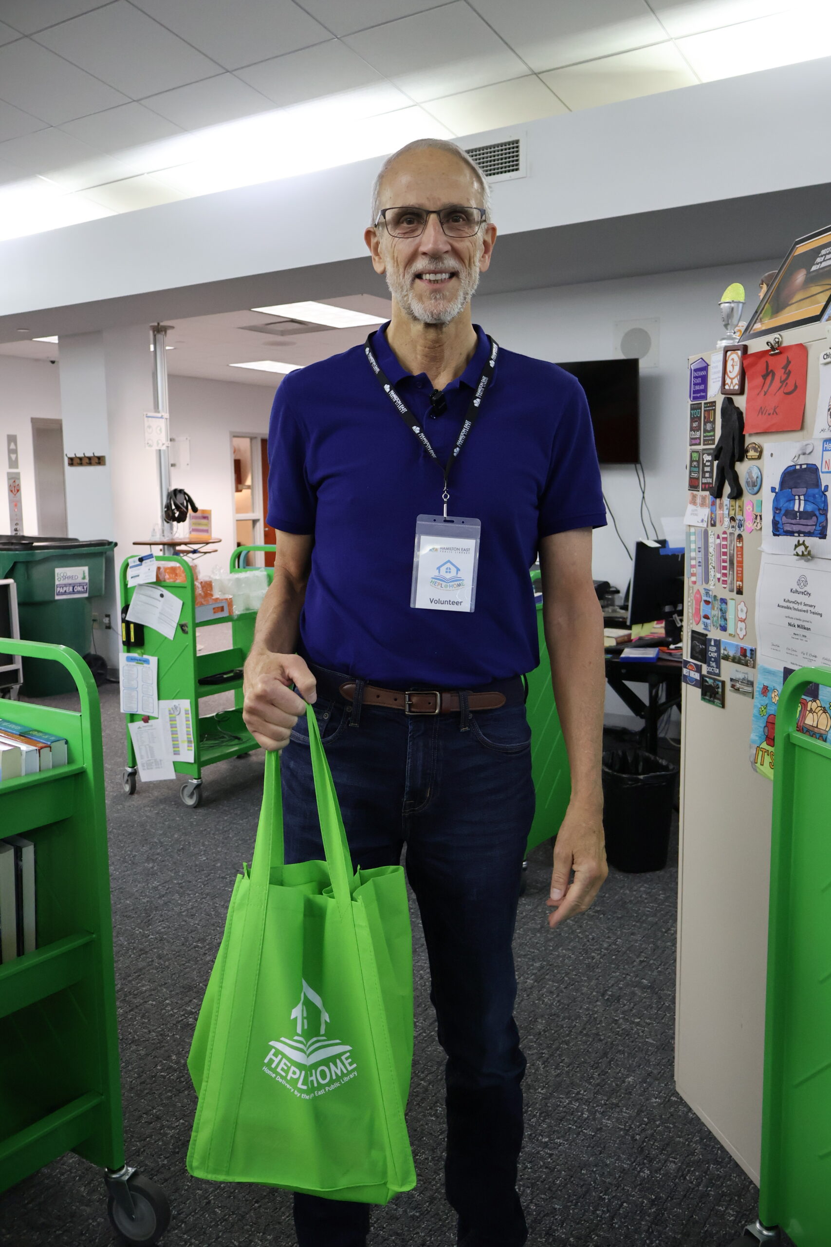 man smiling holding green home delivery bag
