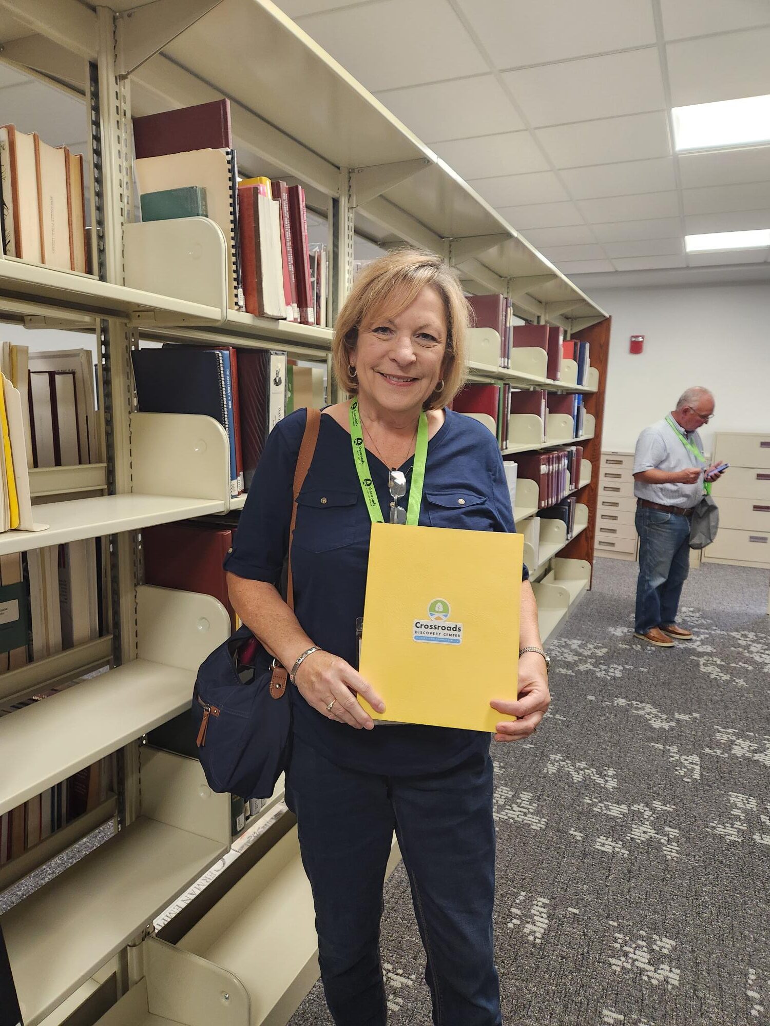 woman smiling holding yellow folder